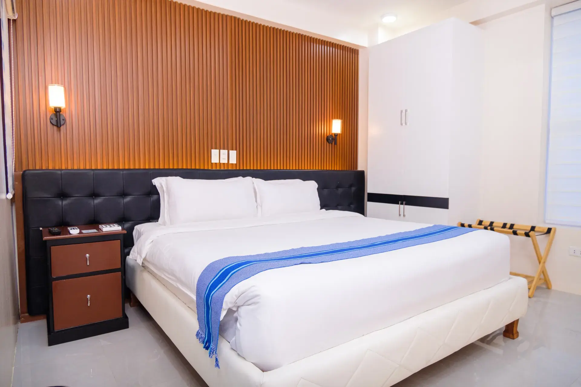 Executive King Room: the bed, with a blue runner, beside a bedside table