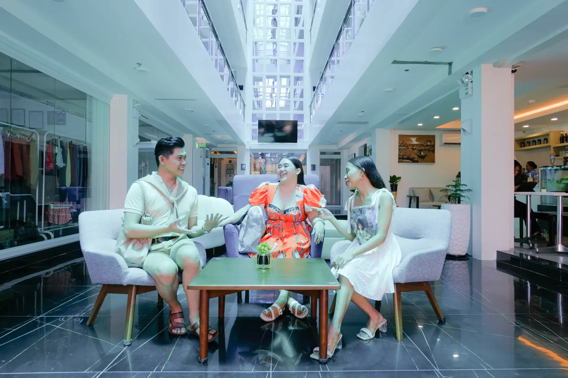 Three guests chatting in the lobby's lounge chairs