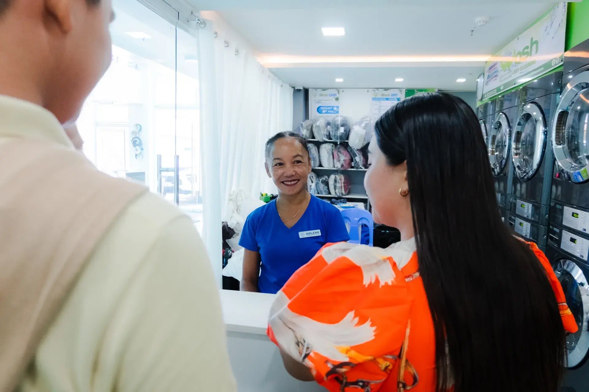 An iWash attendant greeting a guest at the counter