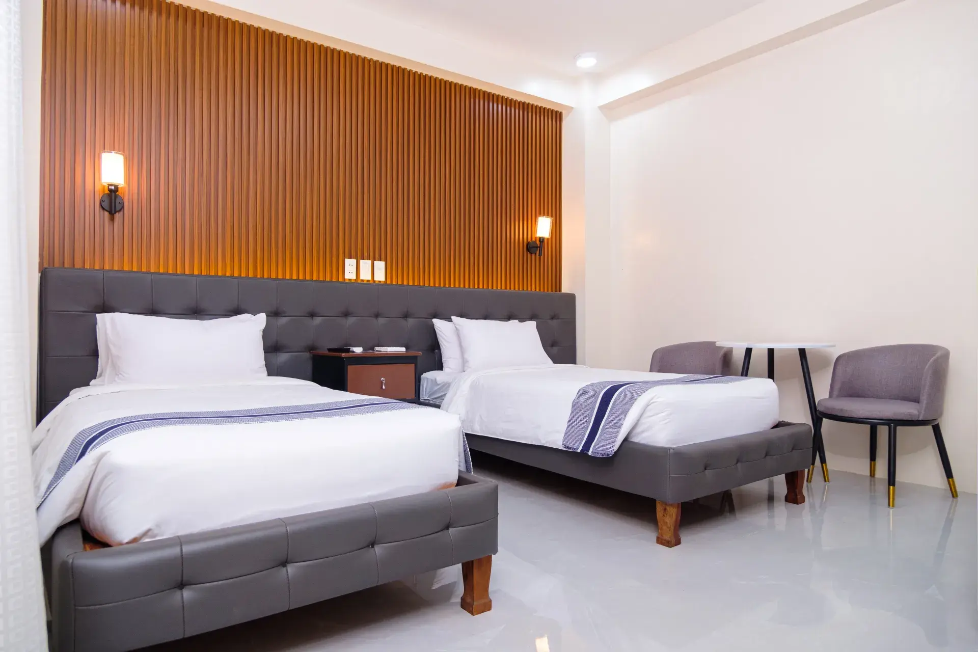 Deluxe Twin Room: two single beds, two armchairs and a small table