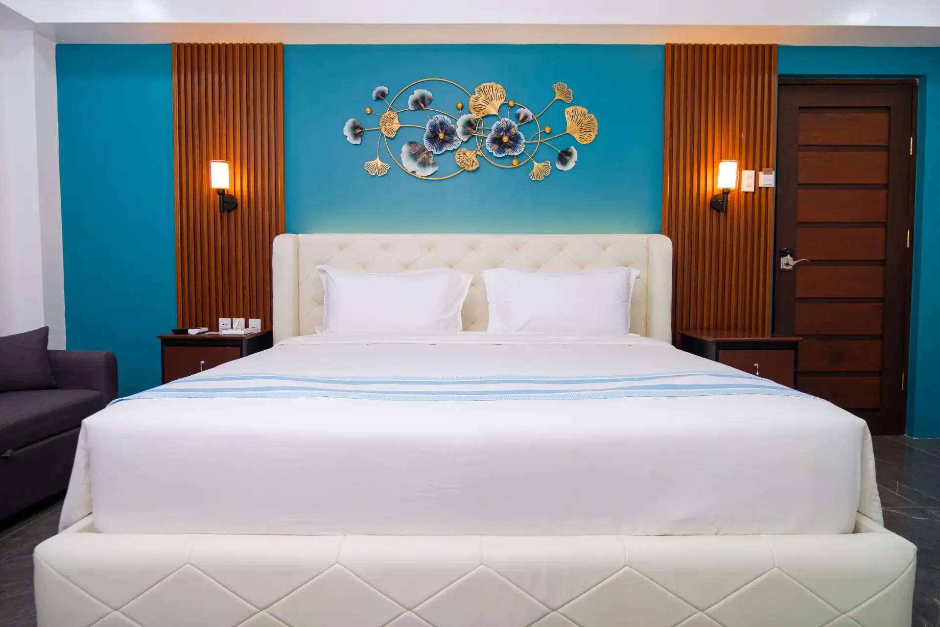 Premier Room: the bed, under metal flower art on a teal wall